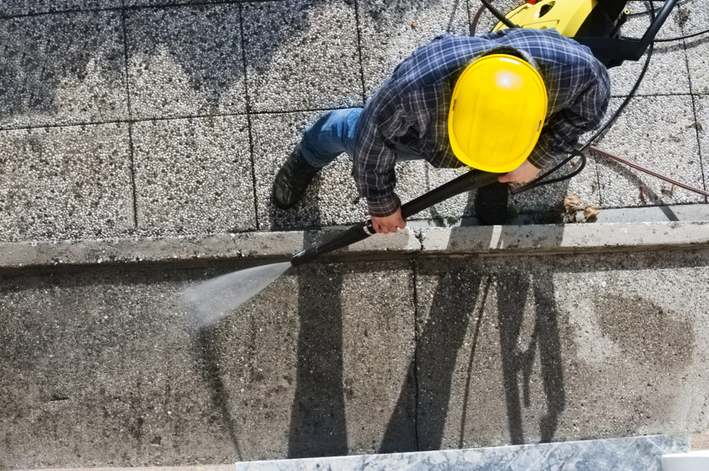 Young men cleaning  terrace  with high-pressure