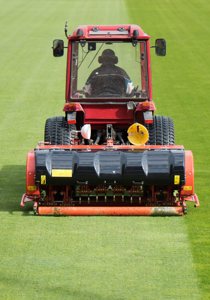 Grounds Keeper Conducting Landscape Maintenance Services In A Commercial Lawn Mower