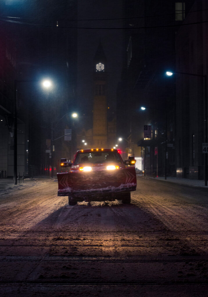 Photo Of A Snow Plow Truck In The Middle Of The Road In A City At Night